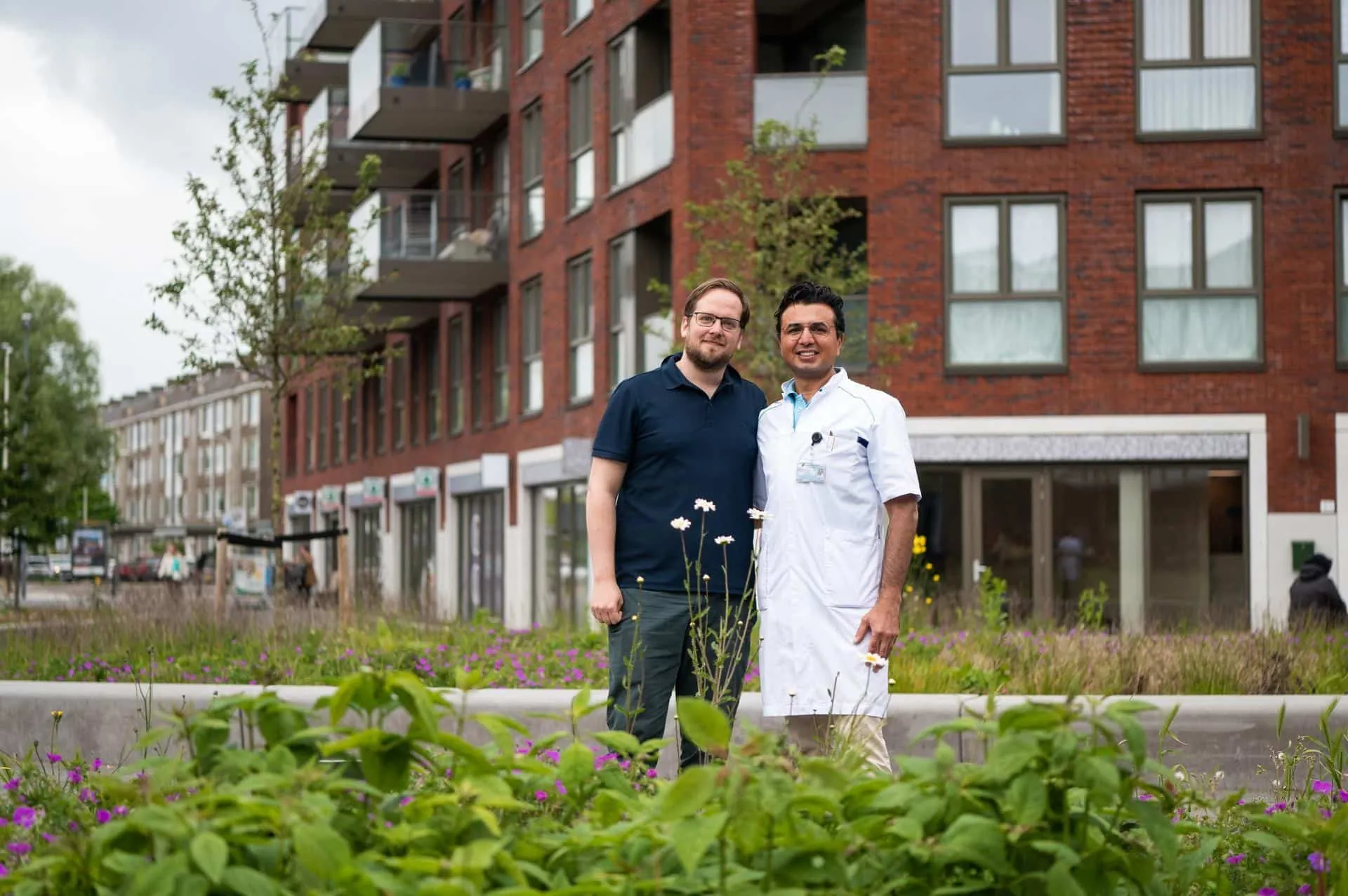 Samer Somi in doktersjas en een collega voor het pand van Leefstijlcentrum Haaglanden, kort na de opening in 2023